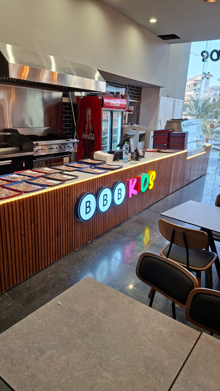 Illuminated channel letters above a retail sales counter — BBB Kids store interior