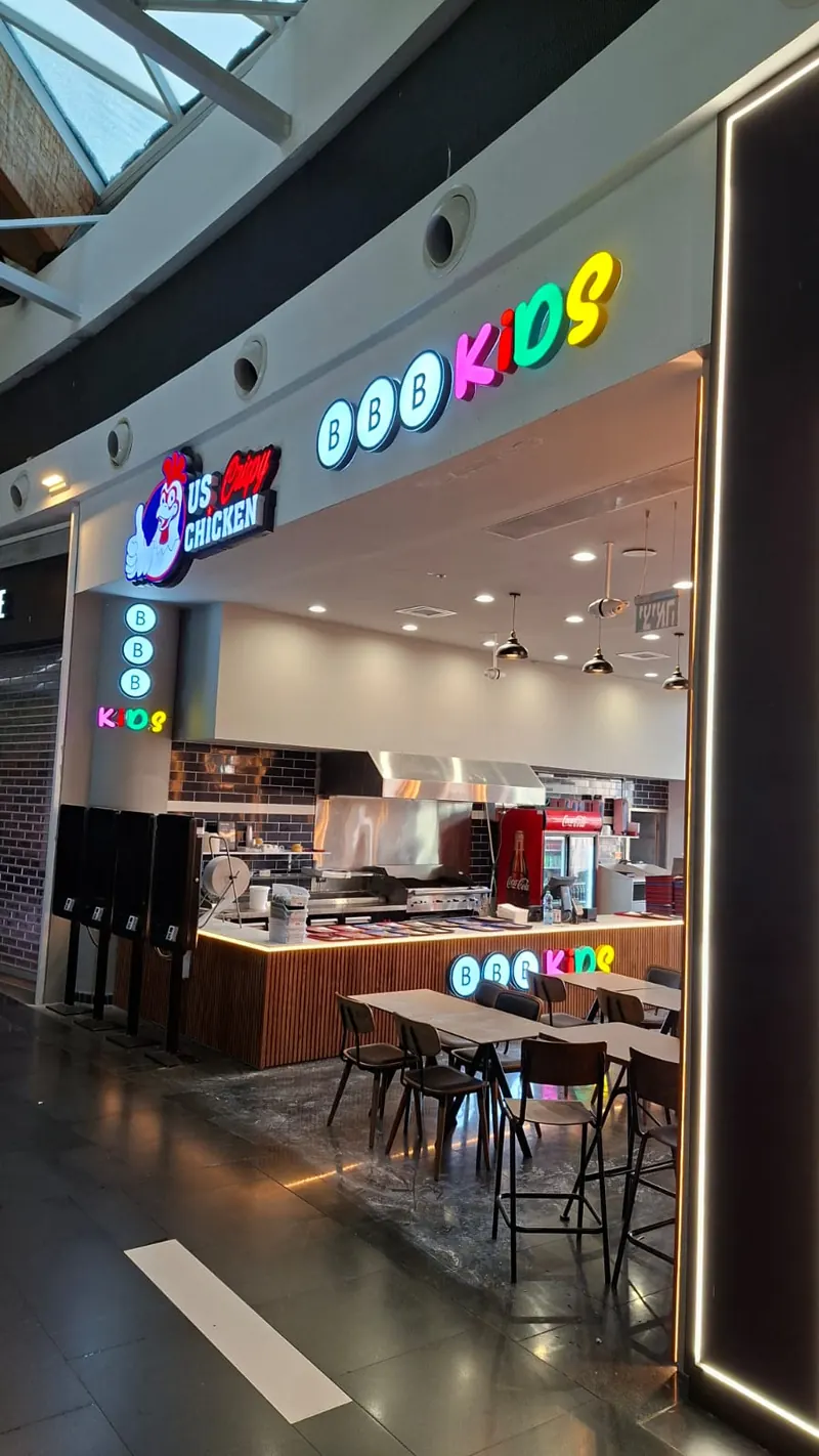 Two illuminated brand signs side by side above a shared shopfront entrance