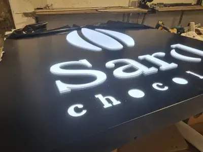 A lit sign on the workshop bench before installation