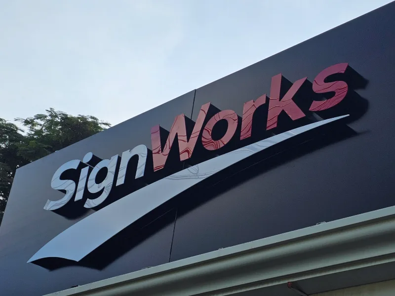 Primer plano de letras 3D SignWorks sobre fachada negra, de día — SignWorks Costa Rica