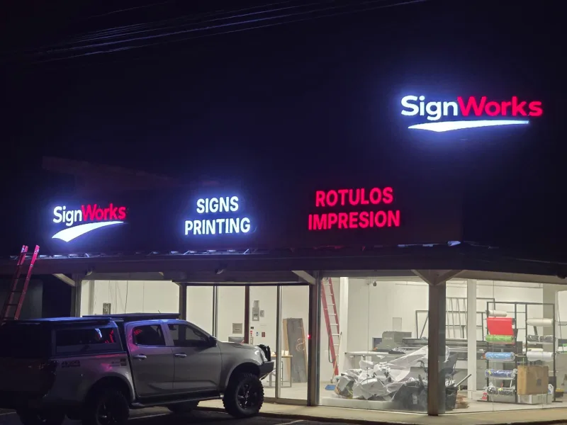 SignWorks shop at night in Guanacaste, with the logo on the roof and the facade letters lit