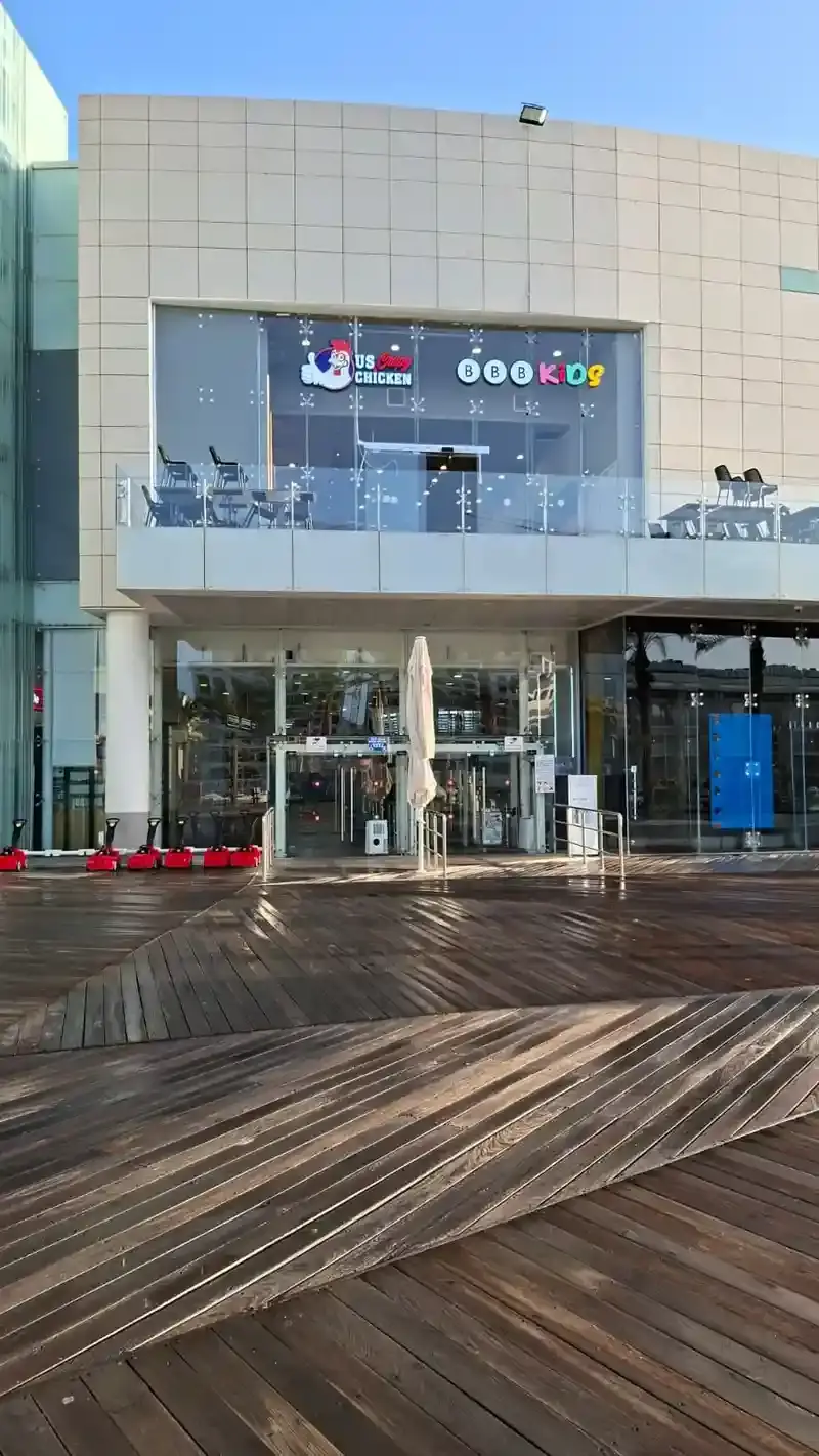 Both brand marks repeated on the upper-level glazed elevation of the building