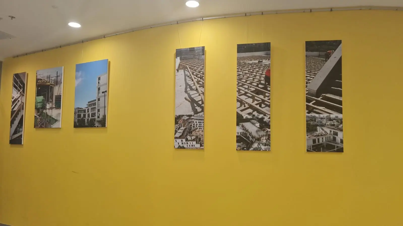 Pared amarilla con decoración de fotos de obra de construcción — SignWorks